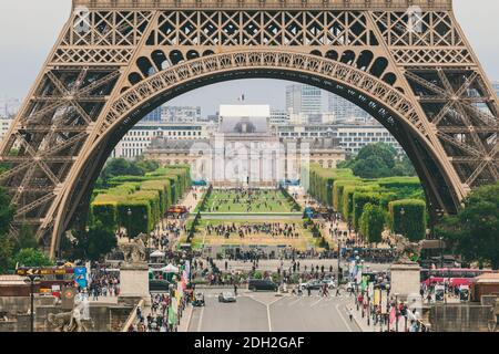 Parigi, Francia 24 luglio 2017: Torre Eiffel primo piano di una strada con auto e autobus traffico da un trasportatore, passaggio sotto un ar Foto Stock