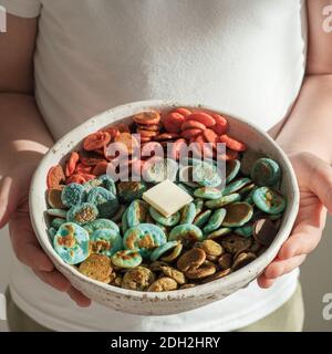 Cereali con frittelle colorate nelle mani del bambino Foto Stock