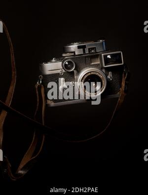 Fotocamera d'epoca con film in primo piano, corpo della fotocamera e livitazione dell'obiettivo Foto Stock