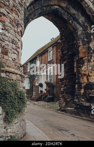 Rye, UK - 10 ottobre 2020: Tradizionale cottage inglese a Rye, una delle città medievali meglio conservate in Inghilterra, visto attraverso il muro di pietra Landgate Foto Stock