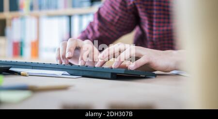 Concetto di ufficio domestico: L'uomo lavora in ufficio domestico, legando sulla tastiera Foto Stock