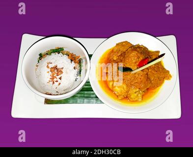 Delizioso pranzo asiatico con una ciotola di riso e verdure fritte e un piatto di fagioli e gnocchi ubriachi, isolato su uno sfondo viola Foto Stock