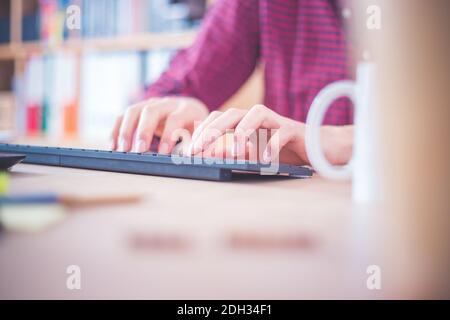 Concetto di ufficio domestico: L'uomo lavora in ufficio domestico, legando sulla tastiera Foto Stock