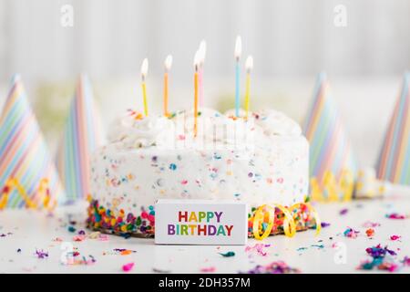 Festeggiate una festa di compleanno gioiosa con una torta colorata e decorazioni natalizie in un ambiente allegro Foto Stock