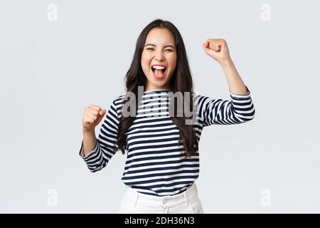 Stile di vita, emozioni della gente e concetto casual. Entusiasta donna asiatica felice partecipare alla competizione sportiva, cannonaggio e cannonaggio per la squadra Foto Stock