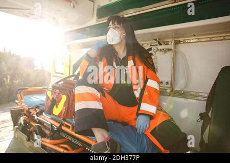 Giovane paramedica femminile si siede nel veicolo di emergenza Foto Stock