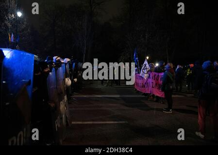 Varsavia, Varsavia, Polonia. 9 Dic 2020. I manifestanti hanno un cartello e affrontano i funzionari di polizia durante una protesta contro il cambiamento climatico il 9 dicembre 2020 a Varsavia, Polonia. Alcune centinaia di manifestanti si sono riuniti davanti alla cancelleria del primo ministro polacco, Mateusz Morawiecki, per protestare contro la mancanza di azione da parte del governo per raggiungere la neutralità del carbonio entro il 2030 e il veto sul bilancio dell'Unione europea, che potrebbe aiutare la Polonia a raggiungere l'obiettivo. Credit: Aleksander Kalka/ZUMA Wire/Alamy Live News Foto Stock