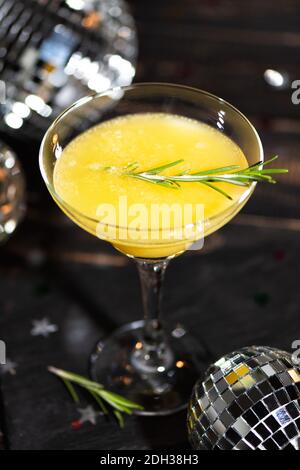Cocktail Mimosa con succo d'arancia e champagne nei colori alla moda grigio e giallo illuminante del 2021. Festa di Capodanno o di compleanno con un disco a specchio Foto Stock