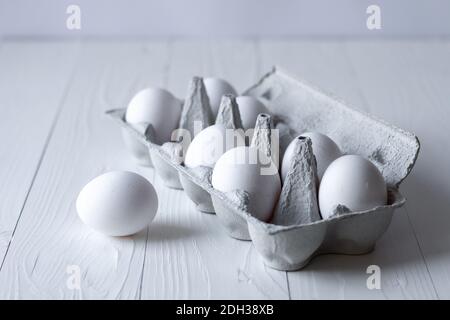 uova bianche su sfondo bianco di legno Foto Stock