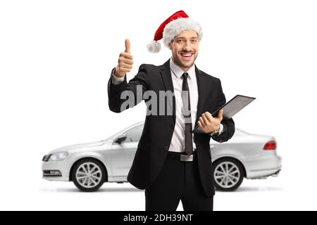 Uomo con un'auto d'argento che indossa un babbo natale cappello e mostrare i pollici su isolato su sfondo bianco Foto Stock