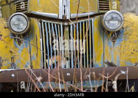 Una vecchia automobile abbandonata di Rusty si siede da sola in UN campo Foto Stock