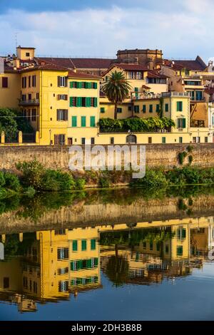 City street view con case e riflessione nel fiume Arno, Firenze, Italia Foto Stock