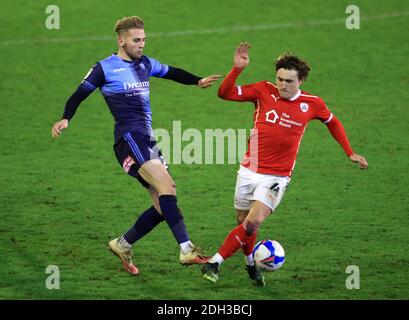 Barnsley's Callum Styles scivola sul Jason McCarthy di Wycombe Wanderers durante la partita del campionato Sky Bet a Oakwell, Barnsley. Foto Stock