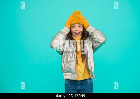 sorpresa bambino in argento gonfie giacca e maglieria ottenere caldo in inverno pronto per attività in vacanza, spazio copia, felicità infanzia. Foto Stock