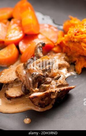 filetto di maiale con salsa di funghi e purè di patate dolci Foto Stock