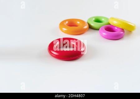 un gruppo di cinque colorati anelli di plastica isolati su uno sfondo bianco. Giocattoli per bambini. Stesse dimensioni per ciascun anello Foto Stock