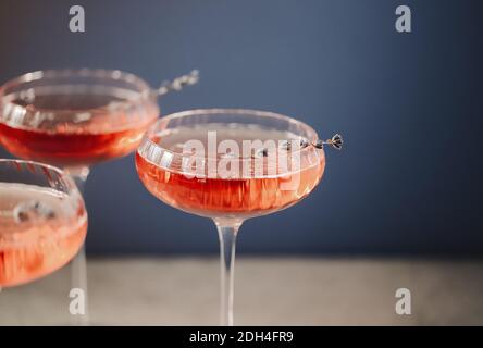 Bicchieri con champagne rosa freddo posti sul tavolo Foto Stock