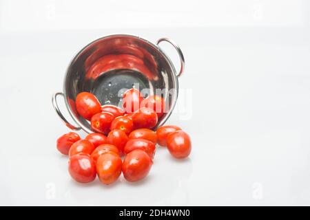 pomodori piccoli e gustosi su sfondo bianco Foto Stock