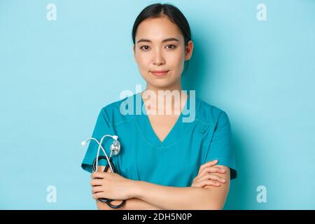 Covid-19, concetto di pandemia di coronavirus e di allontanamento sociale. Primo piano ritratto di sicuro sorridente donna asiatica dottore, infermiera Foto Stock