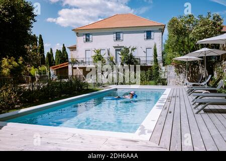 Casa vacanza francese con terrazza in legno e piscina nel Ardeche Francia. Donna relax presso la piscina con ponte in legno durin Foto Stock