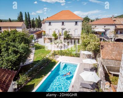 Due persone nuotano nella piscina dell'hotel. Vista dall'alto, coppie di uomini e donne in piscina di casa vacanza di lusso nel Foto Stock