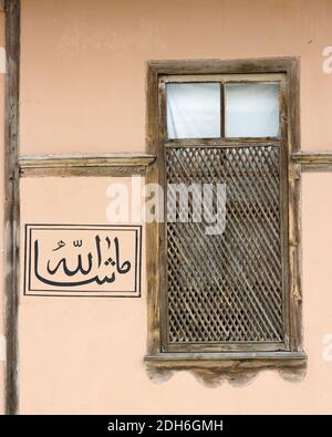 Calligrafia araba e tipica finestra in legno sulla facciata in stile casa ottomana a Safranbolu, Turchia Foto Stock