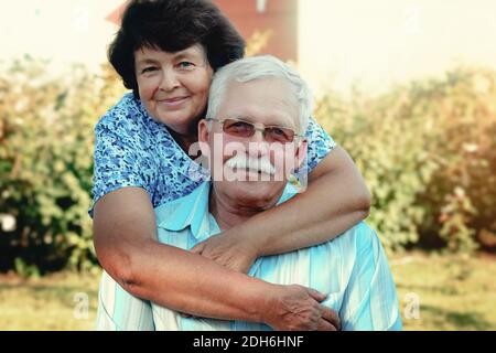 Abbracci di persone mature amorevoli in una giornata estiva nel park.Senior coppia sono seduti outdoors.An anziana donna abbracci un vecchio uomo Foto Stock