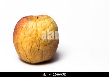 Mela gialla e rossa con rughe profonde su sfondo bianco. Concetto di invecchiamento. Foto Stock