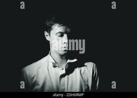 Uomo di mezza età. Nero e bianco ritratto drammatico, tasto basso. Foto Stock