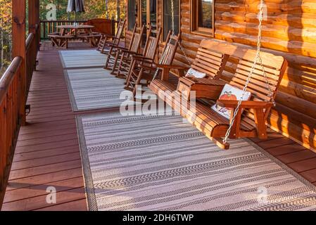 I dondolatori del ponte e l'altalena del portico offrono una splendida vista dell'alba autunnale da questa lussuosa cabina di legno sul lago delle Blue Ridge Mountains della Georgia. (STATI UNITI) Foto Stock