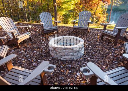 Sedie Adirondack cerchiate intorno a un caminetto in una lussuosa cabina sul lago in un bellissimo giorno d'autunno nelle Blue Ridge Mountains della Georgia settentrionale. (STATI UNITI) Foto Stock