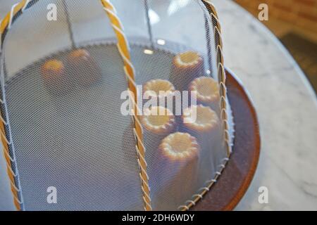 Il Canelé (Canele) de Bordeaux, pasticceria francese confezione ricca cudy interno racchiuso da una sottile conchiglia caramellata Foto Stock