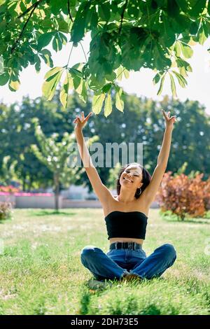 Libertà felice afro donna americana con le braccia in su rilassarsi parcheggio Foto Stock