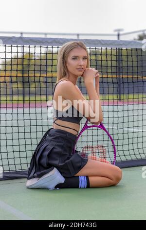 Un bel modello Blonde gioca a tennis su un caldo Summers Giorno Foto Stock