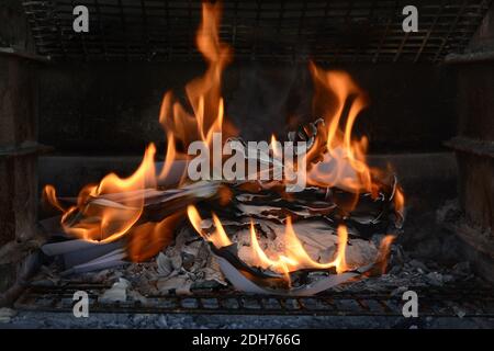 Masterizzazione di documenti cartacei. Fiamme e carta bruciata. Buon esempio di distruggere la prova bruciandola. Ceneri lasciate dietro. Foto Stock