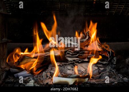 Masterizzazione di documenti cartacei. Fiamme e carta bruciata. Buon esempio di distruggere la prova bruciandola. Ceneri lasciate dietro. Foto Stock