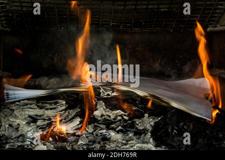 Masterizzazione di documenti cartacei. Fiamme e carta bruciata. Buon esempio di distruggere la prova bruciandola. Ceneri lasciate dietro. Foto Stock