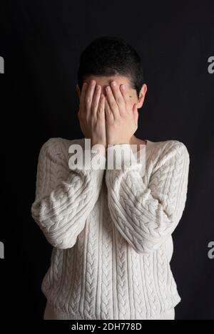 Giovane donna stressata con capelli corti che nascondono il viso con le mani Foto Stock