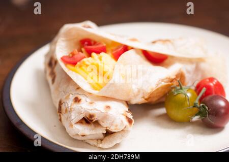 prima colazione burrito con formaggio, uova e pomodori ciliegini al telaio Foto Stock