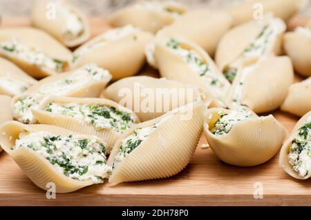 pasta conchiglie farcita a mano senza cottura con formaggio di capra e spinaci e una salsa marina Foto Stock