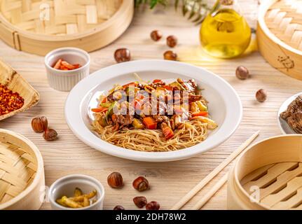 Piatto di tagliatelle saltate in padella con maiale e verdure. Tradizionale cinese chow mein Foto Stock