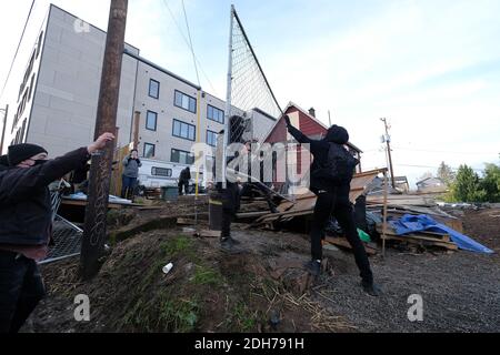 Portland, Stati Uniti. 8 dicembre 2020. I manifestanti hanno ricommissionato una recinzione come barricata dopo che la polizia si è ritirata dalla Casa Rossa in Mississippi Street a Portland, Ore., l'8 dicembre 2020, durante un tentativo di sgombrare la proprietà. Gli attivisti si sono accampati fuori dalla casa da settembre sperando di mantenere la famiglia nera e indigena che vivono lì ospitato dopo che un giudice della contea di Multnomah ha autorizzato lo sfratto. (Foto di Alex Milan Tracy/Sipa USA) Credit: Sipa USA/Alamy Live News Foto Stock