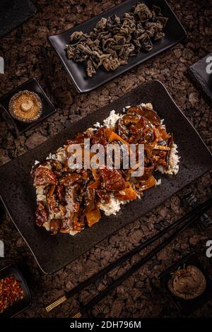 Fette di manzo in salsa marrone piccante con bambù e. shiitake servito con riso bianco bollito Foto Stock