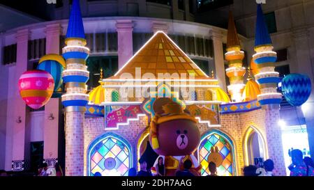SINGAPORE, SINGAPORE - 11 novembre 2019: Un grande orsacchiotto bruno in costume di Babbo Natale di fronte a una colorata moschea illuminata all'ingresso di un centro commerciale, Orcha Foto Stock
