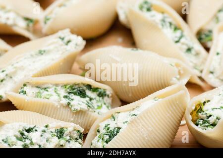 pasta conchiglie farcita a mano senza cottura con formaggio di capra e spinaci e una salsa marina Foto Stock