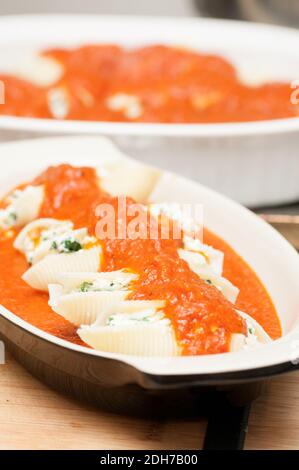 pasta conchiglie farcita a mano senza cottura con formaggio di capra e spinaci e una salsa marina Foto Stock