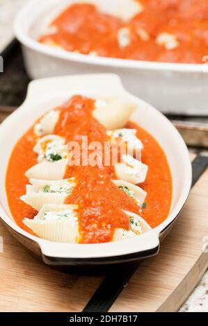 pasta conchiglie farcita a mano senza cottura con formaggio di capra e spinaci e una salsa marina Foto Stock