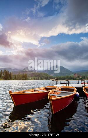 Barche rosse su un lago Strbske pleso. High Tatra montagne parco nazionale e bellissimo lago di montagna in Slovacchia Foto Stock