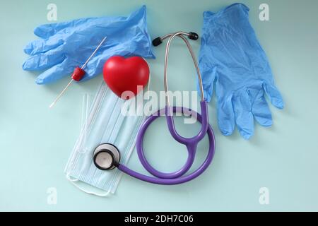 Sul tavolo sono presenti guanti di protezione, uno stetoscopio e un test per la consegna per l'analisi Foto Stock