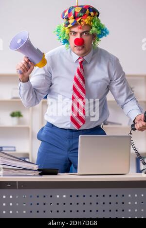 Divertente impiegato clown che lavora in ufficio Foto Stock